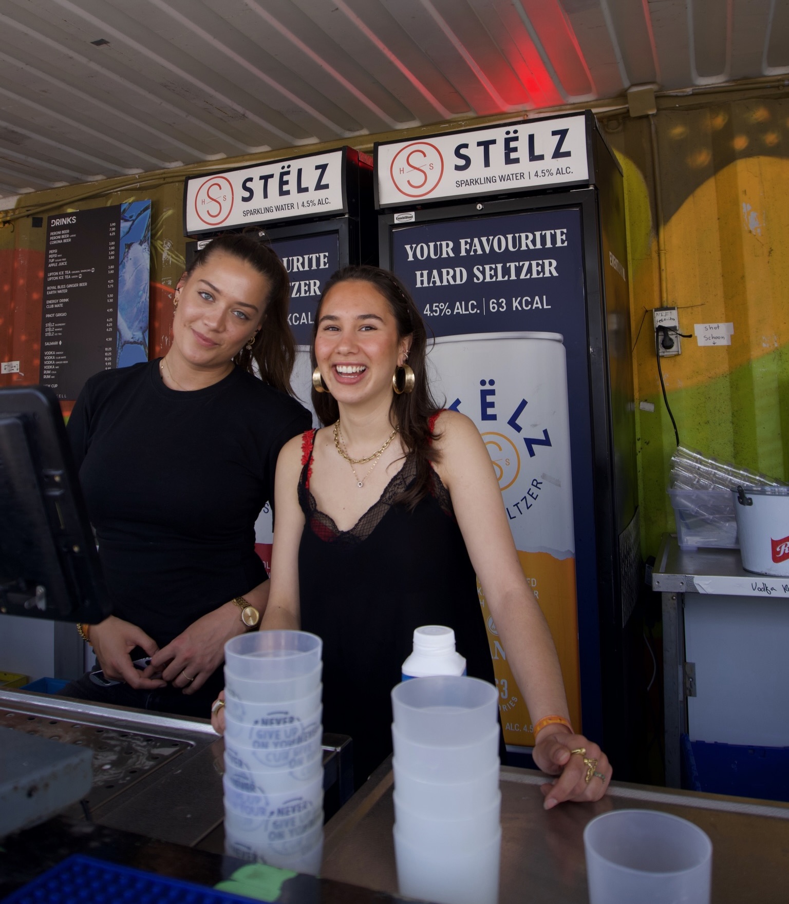 Twee vrolijke Crewmates werken samen achter de festivalbar
